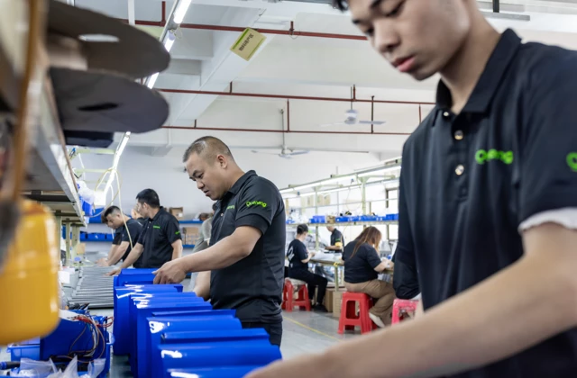 Workers assembling lithium batteries for solar street lights at Queneng factory production line